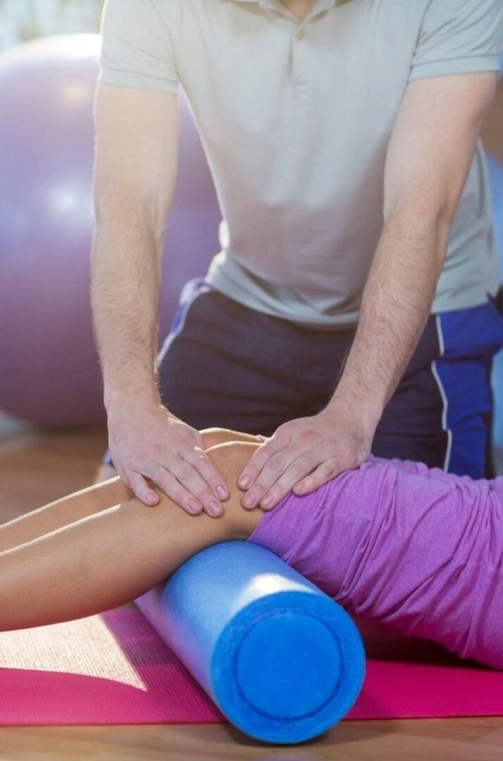 Physiotherapist assisting woman while exercising