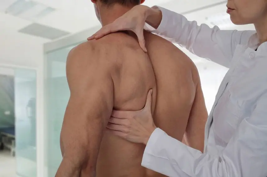 Therapist doing healing treatment on man's back