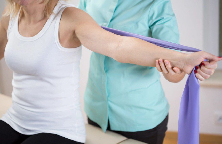 Woman at physiotherapist office exercising with band