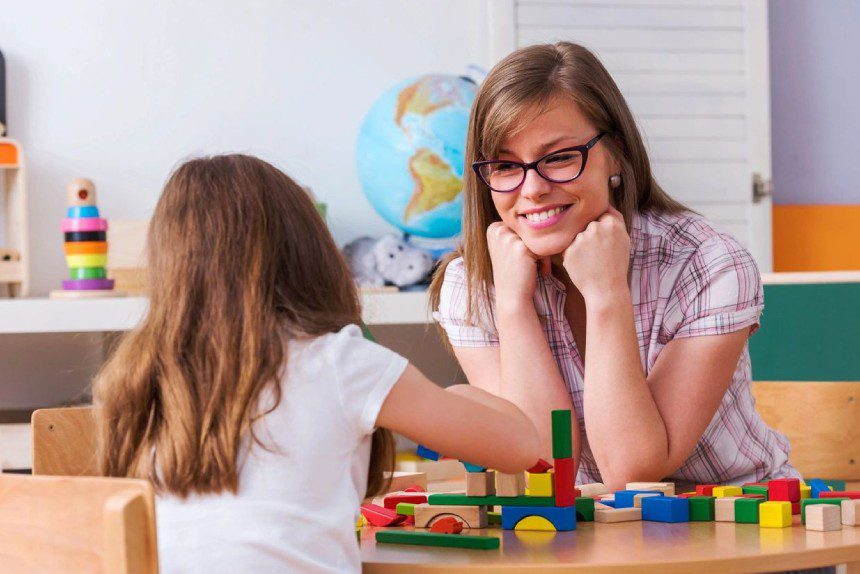 A female occupational therapist is doing rehabilitation with a child patien