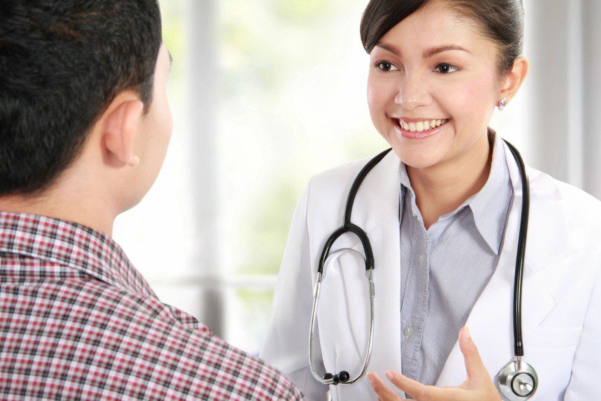 Male patient talking to female doctor at the hospital