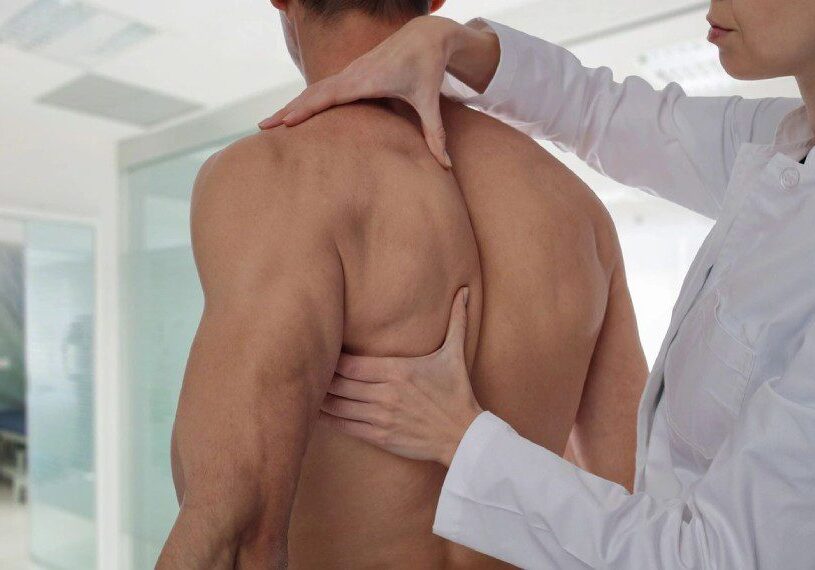 Therapist doing healing treatment on man's back